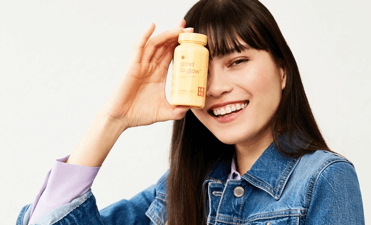 Woman holding bottle to eye